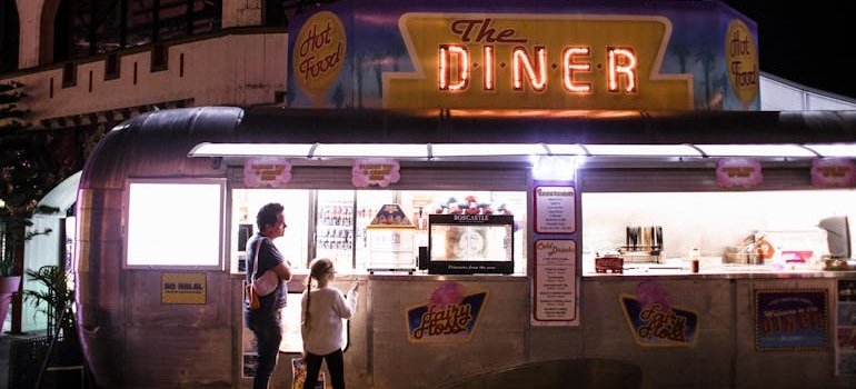 Two people in front of the diner