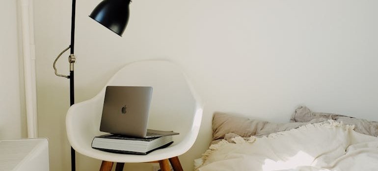 A laptop next to the bed