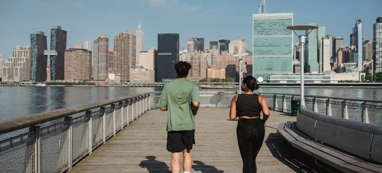 Two people jogging and talking about Manhattan neighborhoods ranked by lifestyle
