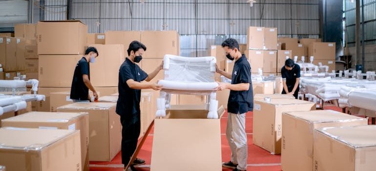 People packing items before storing office furniture
