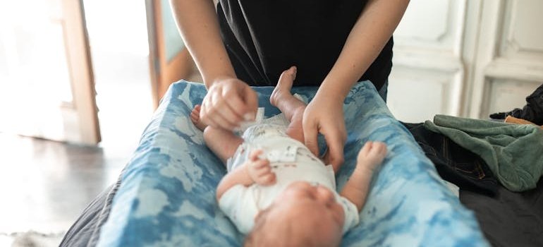 A person changing baby and thinking about storage for new parents in small apartments