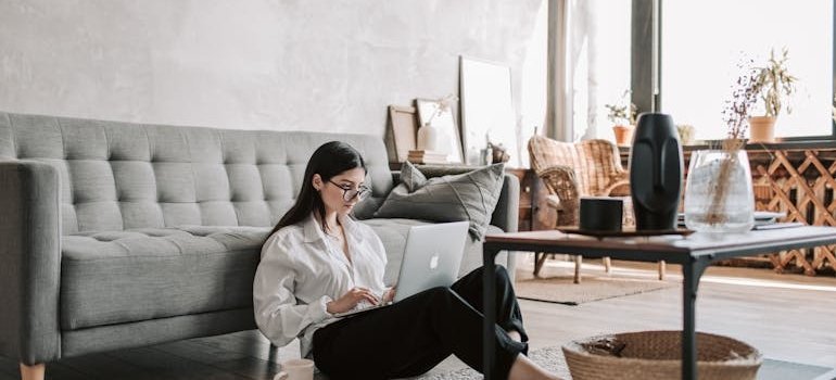 A woman using laptop to find out how student storage makes small NYC apartments livable