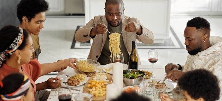 A man who is hosting Easter brunch in a small NYC apartment, sitting with his family