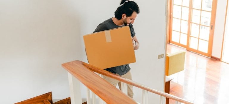 A man carrying a moving box