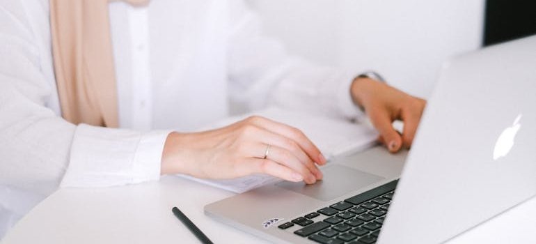 A person using a laptop to research how pickup storage services save time
