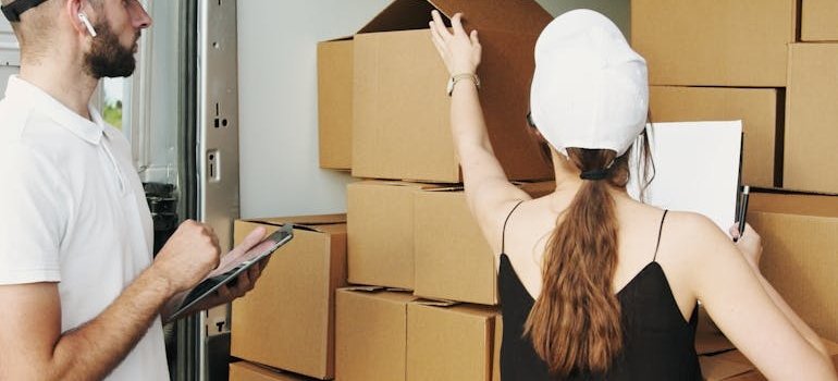 Two people loading boxes and talking about how moving and storage go hand in hand in NYC