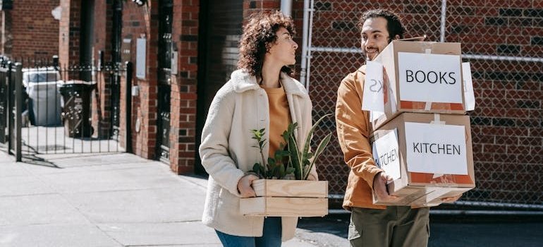 A couple carrying boxes and moving from Long Island City to the Bronx