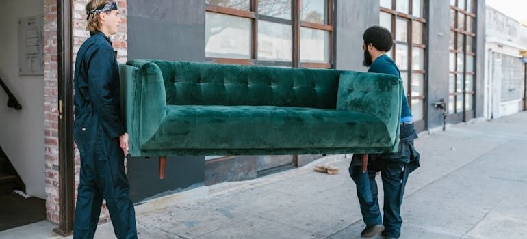 Two men carrying a sofa and talking about storage options for NYC renters between leases