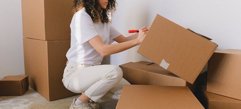 A woman labeling a moving box