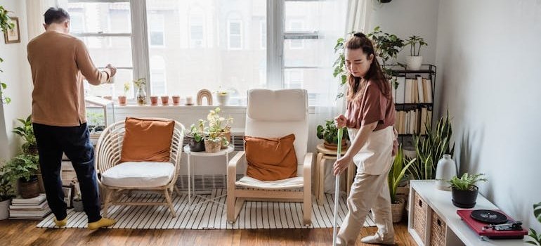 two people cleaning apartment and talking about storing furniture for Airbnb hosts
