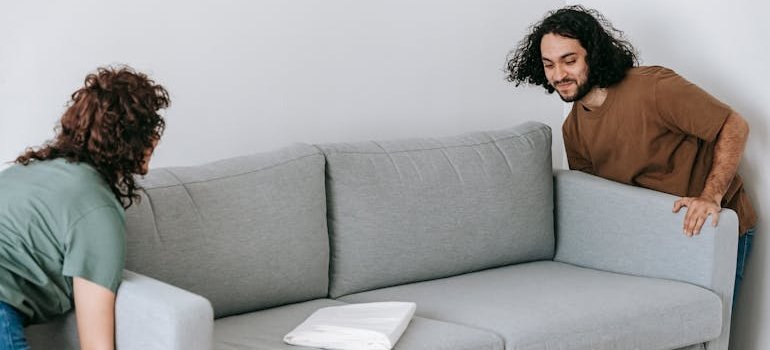 A couple lifting a couch