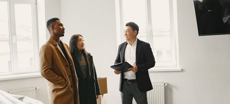 A couple talking with the real estate agent about why NYC residents are moving to Mott Haven