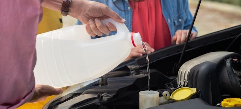 A person pouring a fluid in car before putting your vehicle in storage