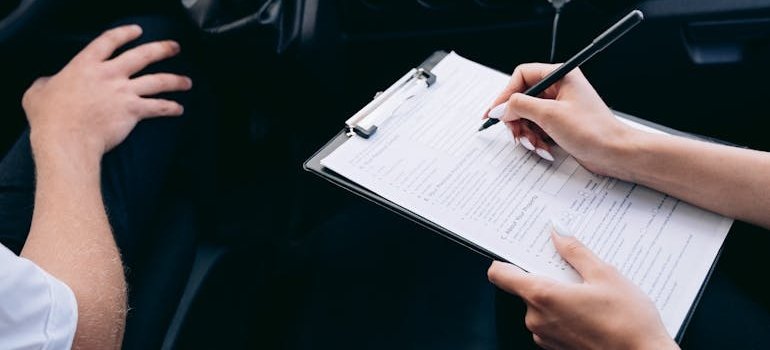 A person filling a document before putting your vehicle in storage