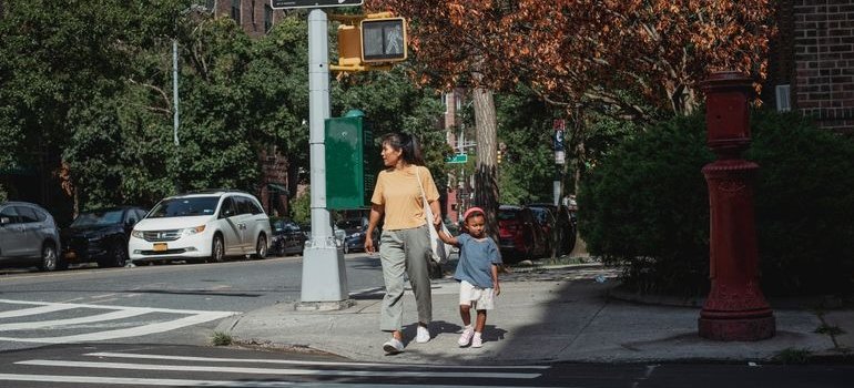 A mother walking with a kid after moving from Castle Hill to the West Village with children