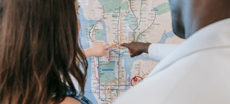 Two people pointing on the map