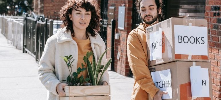 Two people carrying boxes to storage Highbridge NY